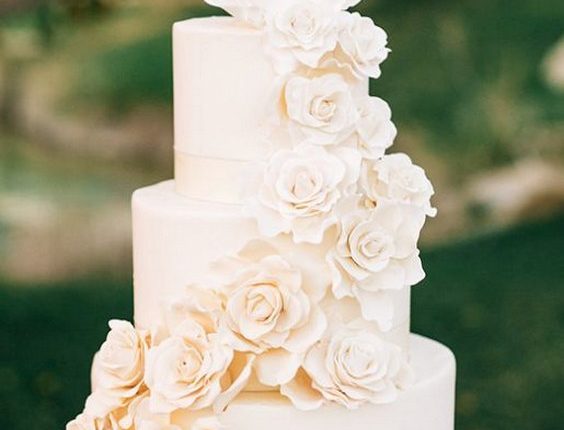 Simply elegant off-white three tier wedding cake wrapped with sugar flowers