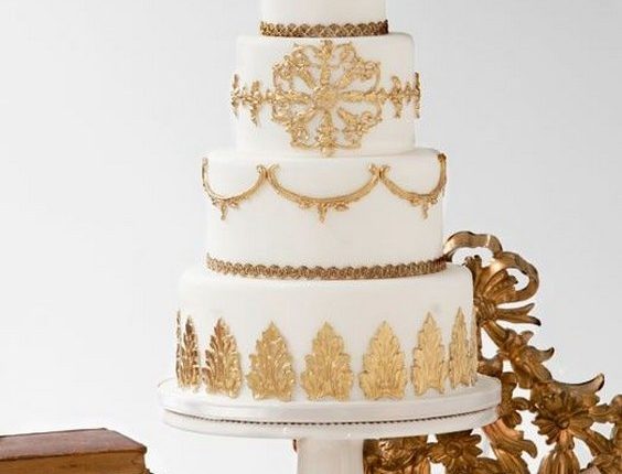 White wedding cake with beautiful gold lace and leaf details