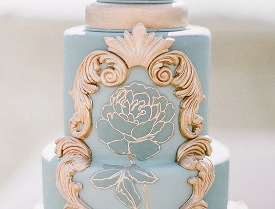 blue wedding cake with golden ornaments and rose
