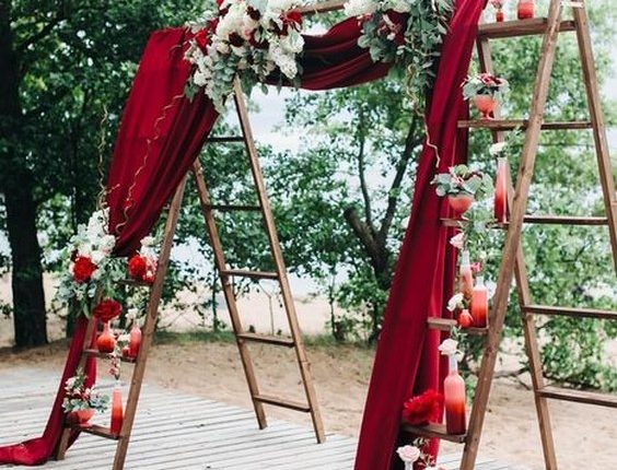 burgundy fabric and ladder wedding backdrop