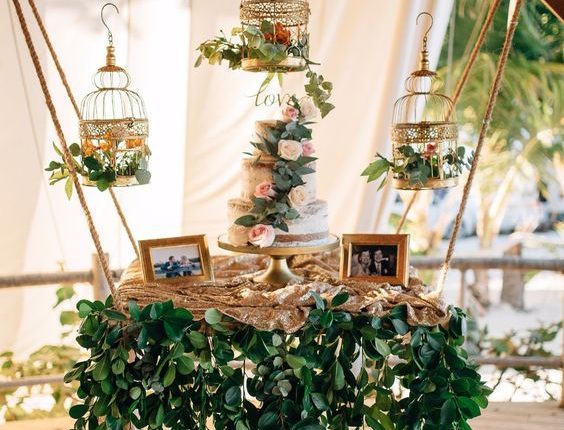 hanging wedding cake table with vintage birdcages and cascading vines