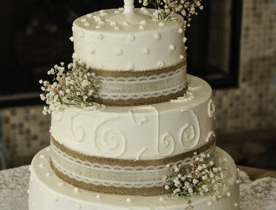 off white wedding cake decorated with burlap lace and babys breath