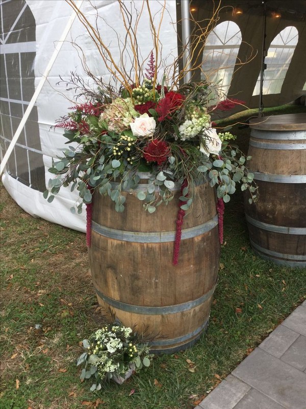 Vineyard themed wedding with rustic arrangements on oversized wine barrels