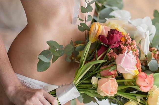 wedding boudoir book the bride in white lace lingerie holds a bouquet bridalboudoir via instagram