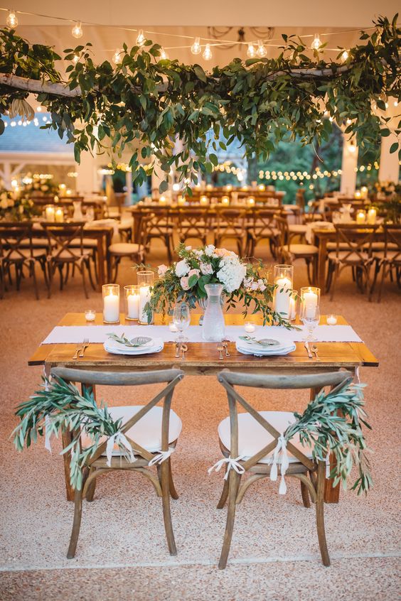 Lush sweetheart table with greenery galore