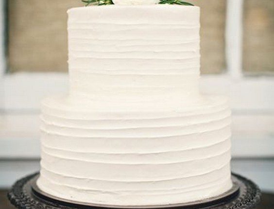 Simple white wedding cake with white flowers on top