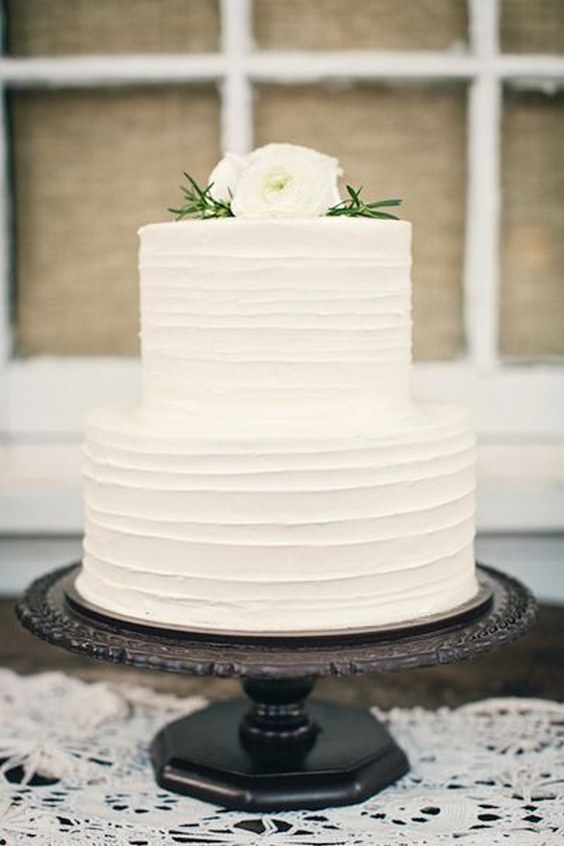 Simple white wedding cake with white flowers on top