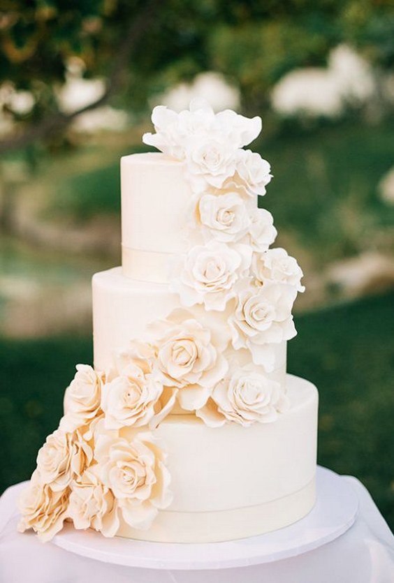 Simply elegant off-white three tier wedding cake wrapped with sugar flowers