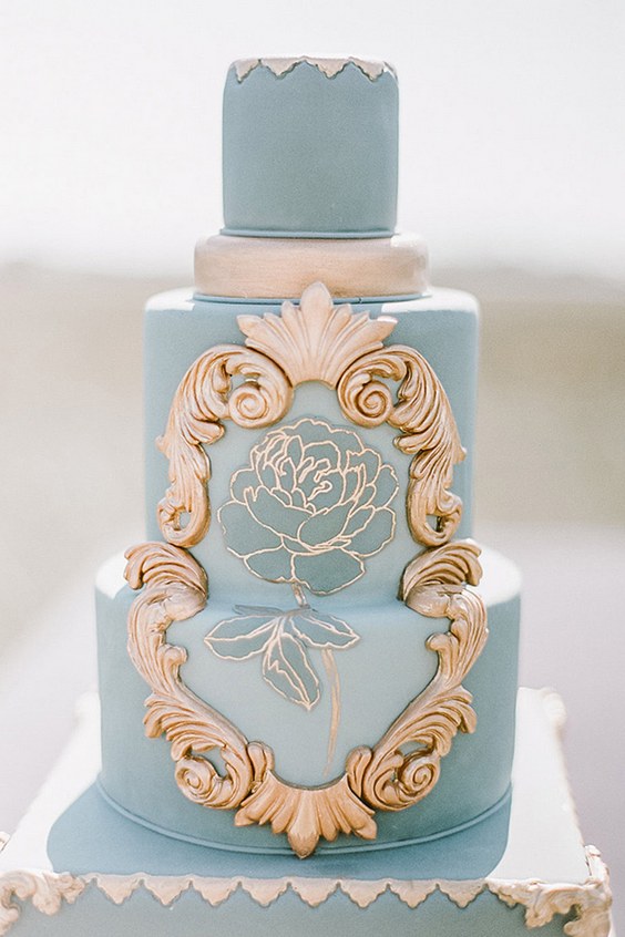 blue wedding cake with golden ornaments and rose