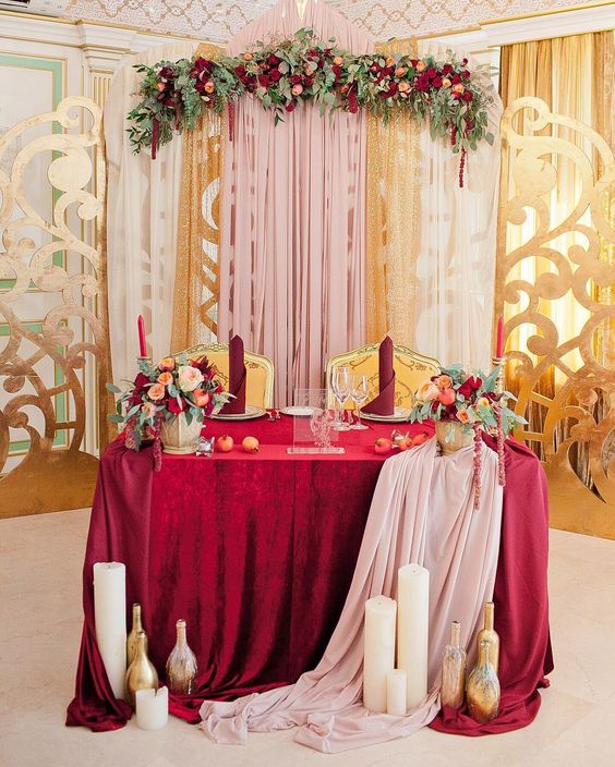 burgundy color tones and floral greenery wedding head table