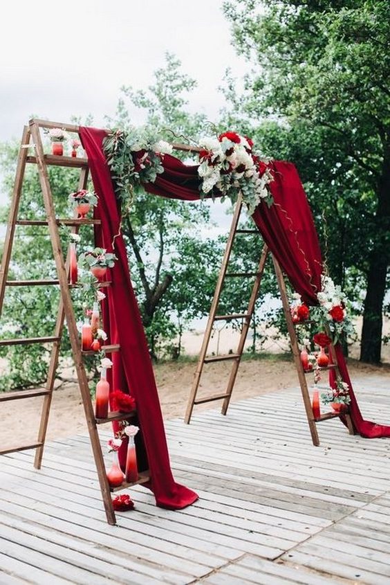 burgundy fabric and ladder wedding backdrop