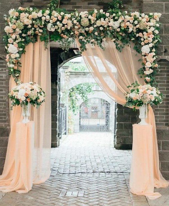 peach and greenery wedding arch