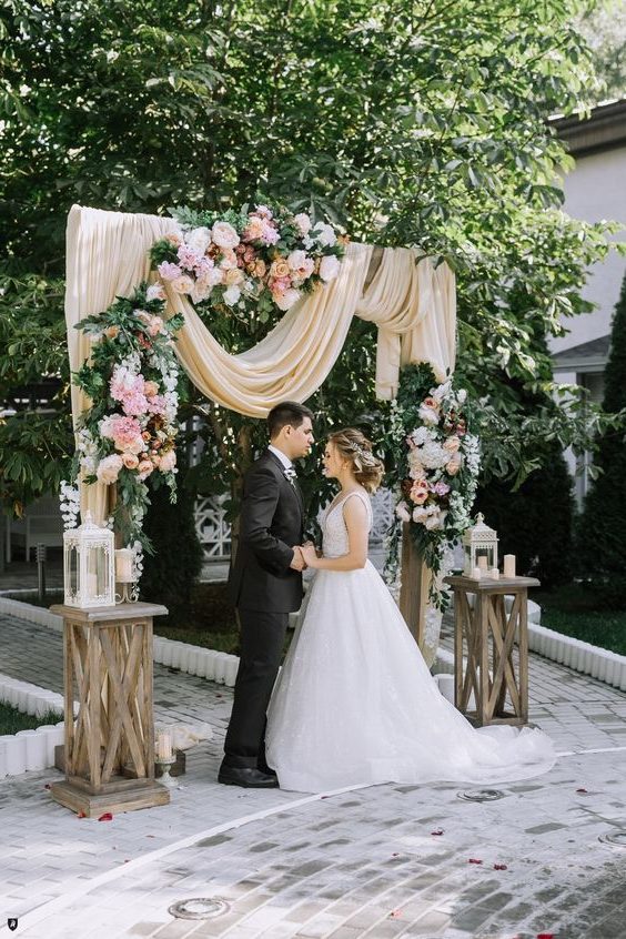 rustic peach fabric and latern wedding arch