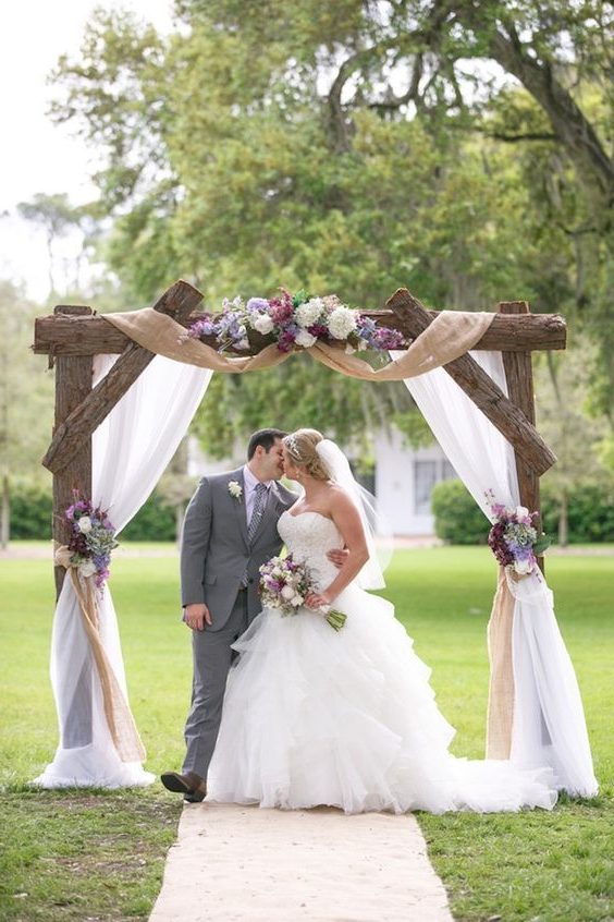 rustic tree stump and burlap outdoor wedding arch