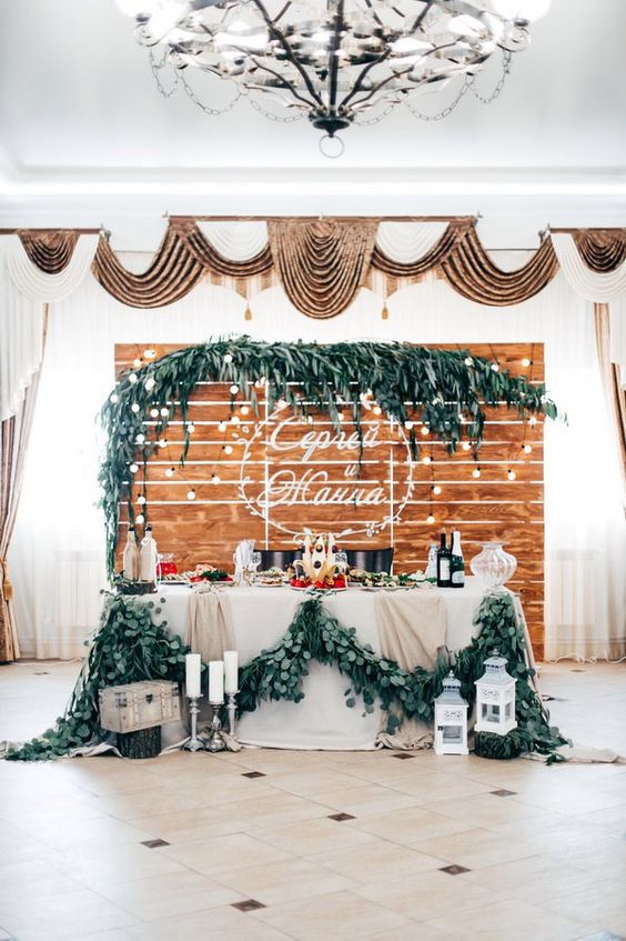 rustic wooden pallet wedding backdrop and sweetheart table with greenery garland