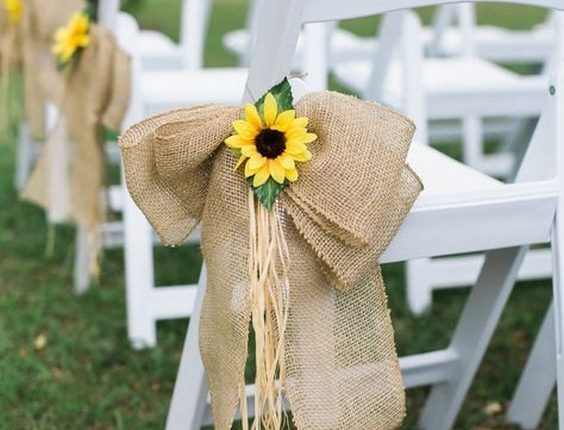 wite wedding chairs were paired with large burlap bows and sunflower