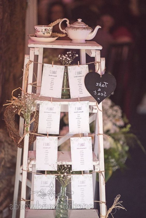 Retro wooden step ladder wedding table plan at barn wedding venue