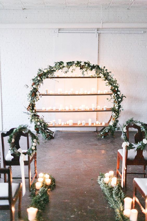 indoor candles and greenery wedding wreath backdrop