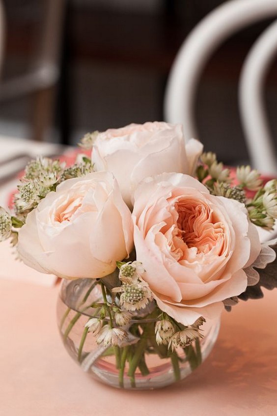 Simple, short pinky peach roses in a glass container filled with water wedding centerpiece