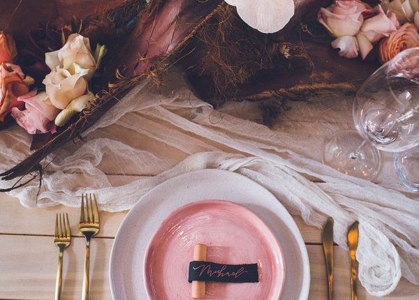 blush and burgundy table setting with gold cutlery