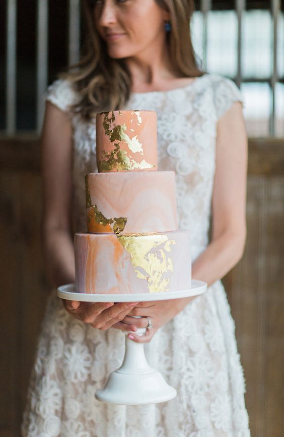 peach-colored wedding cake with gold accents
