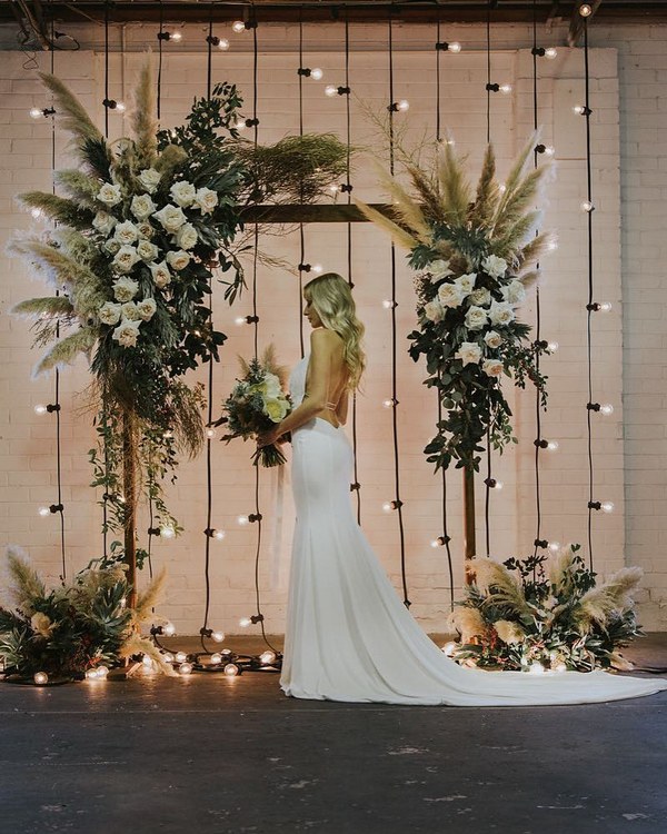 floral wedding arch with pampas plumes and festoon lights