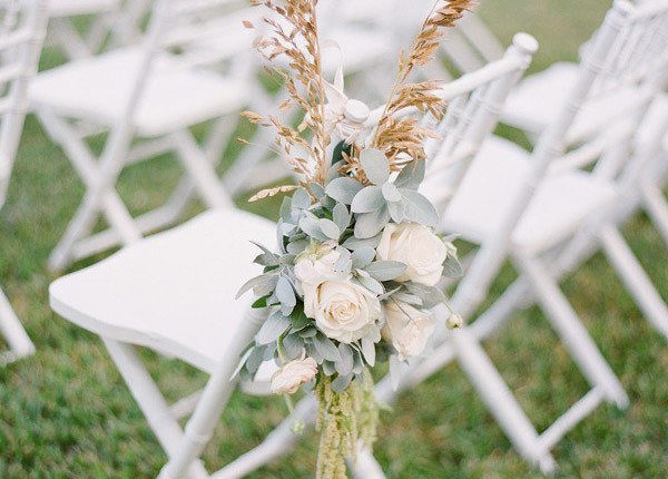 flower arrangement and pampas grass for wedding ceremony chairs