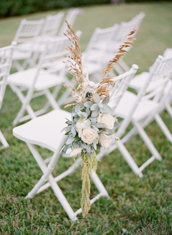 flower arrangement and pampas grass for wedding ceremony chairs