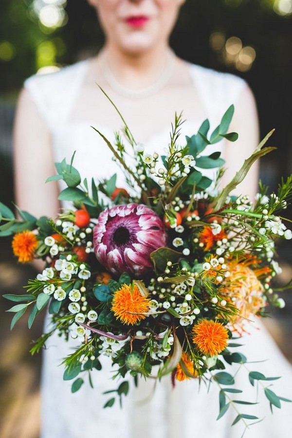 purple and orange wedding bouquet with proteas