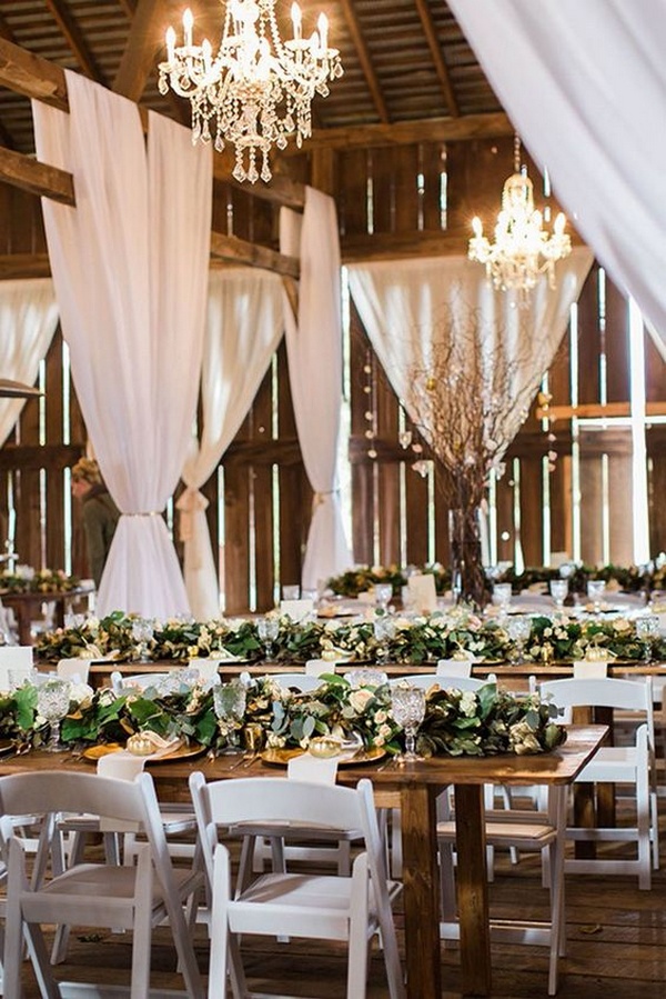 rustic barn wedding reception with greenery on wooden table