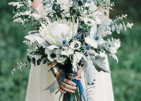 blue and green wedding bouquet with white protea