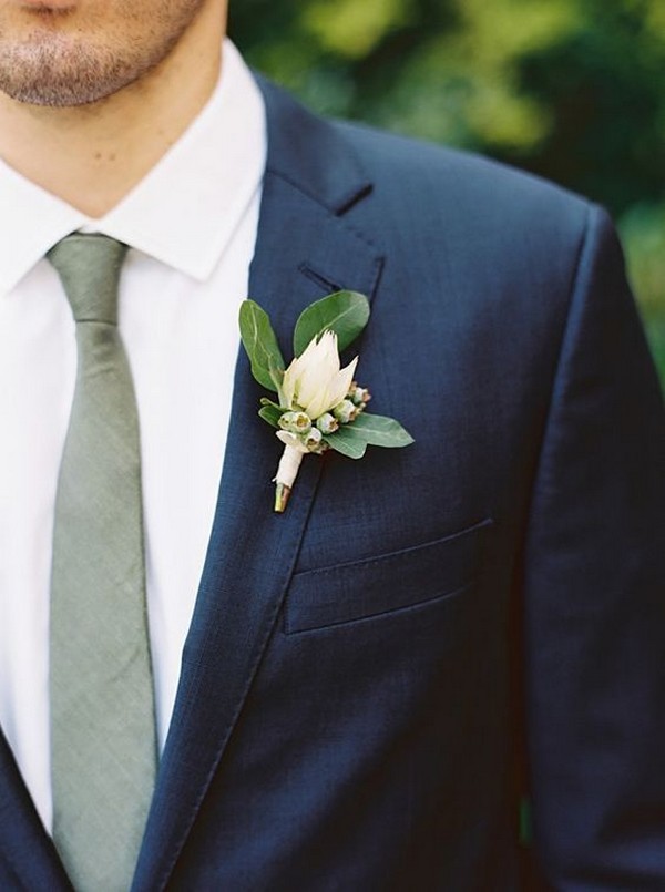 navy blue groom attire with green tie and boutonnier