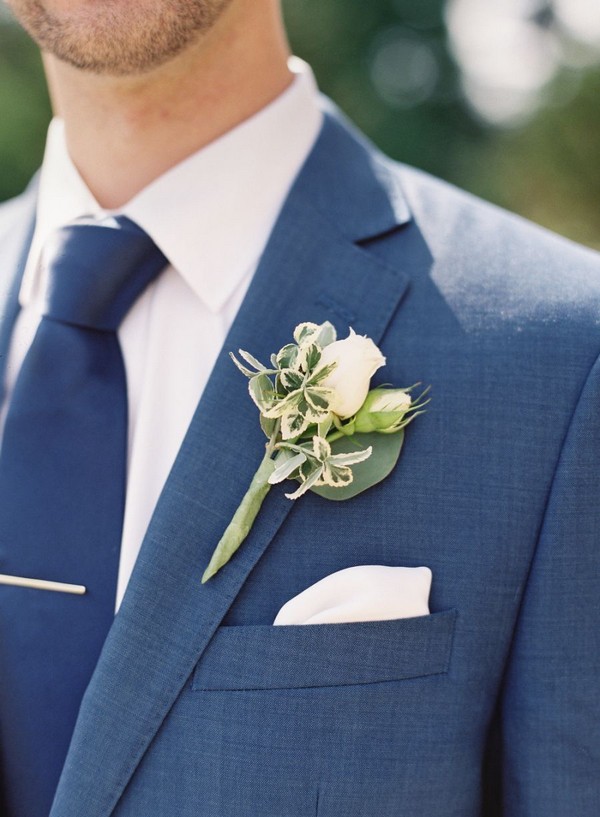 navy blue groom attire with navy tie and green boutonniere