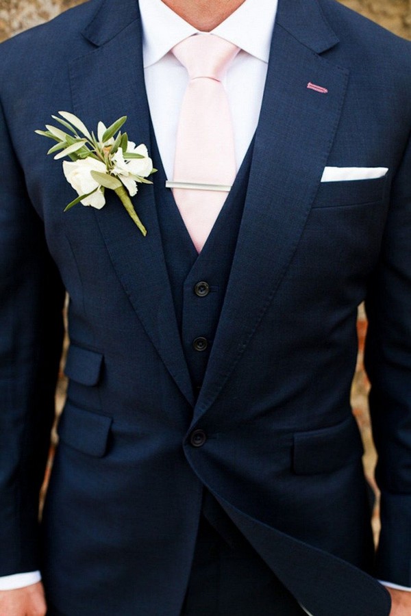 navy blue groom attire with pink tie and greenery boutonniere