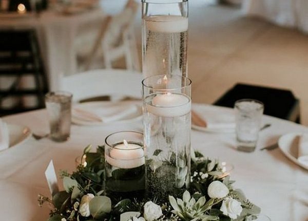 simple wedding centerpiece with candles and greenery