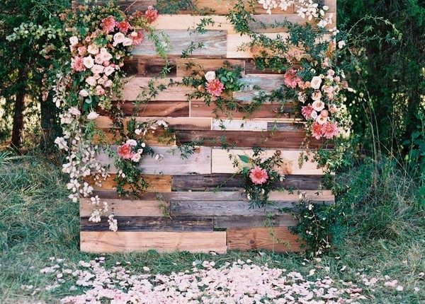 pink blooms and trailing greenery affixed to a free-standing wall of wood panels with a mix of various stains and tones