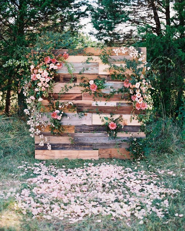 pink blooms and trailing greenery affixed to a free-standing wall of wood panels with a mix of various stains and tones