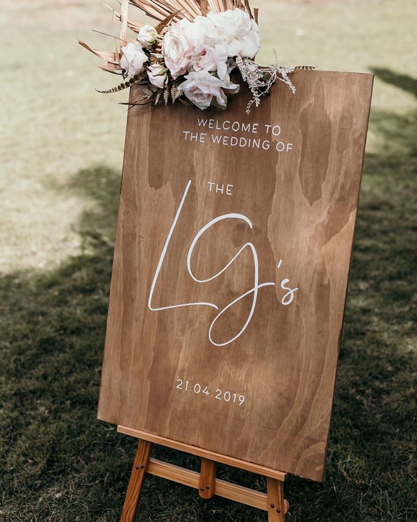 Caramel stained welcome sign with beautiful blush flowers