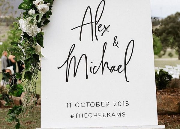 Minimalist white roses and greenery wedding welcome sign