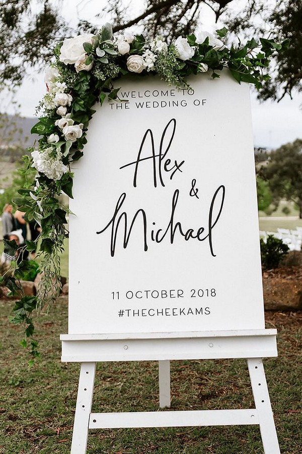 Minimalist white roses and greenery wedding welcome sign