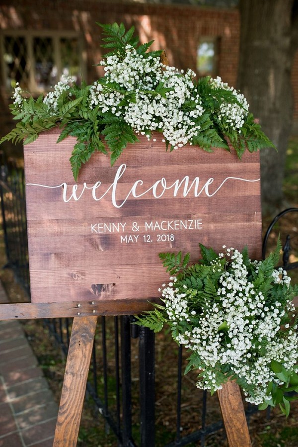Wooden welcome wedding sign with babys breath and greenery swag for rustic winery ceremony
