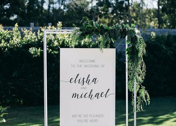 minimalistic simple white wedding welcome sign with greenery leaves