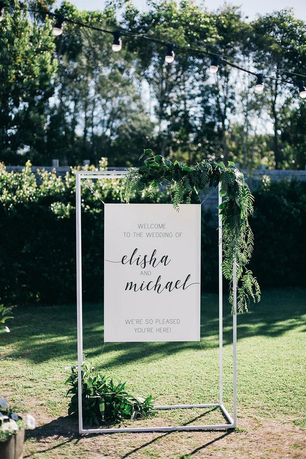 minimalistic simple white wedding welcome sign with greenery leaves