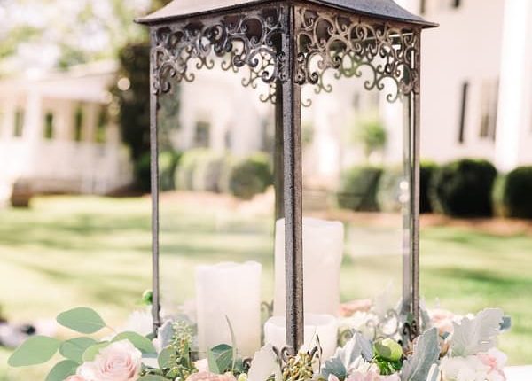 Ornate lantern center piece with pink and white flowers around base