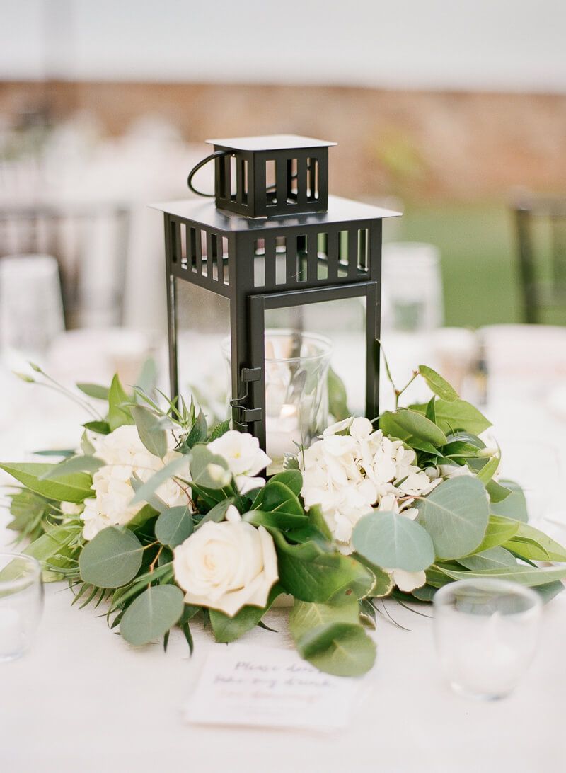 black lantern white roses and green eucalyptus wedding centerpiece
