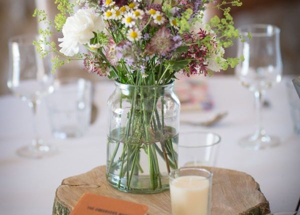 rustic country wildflower and tree stump wedding centerpiece