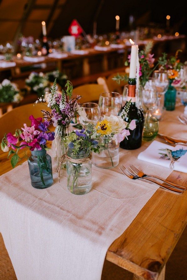 rustic tipi mixed bottles and wildflowers wedding centerpiece