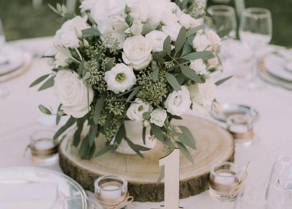 rustic white roses and seeded eucalyptus tree stump wedding centerpiece