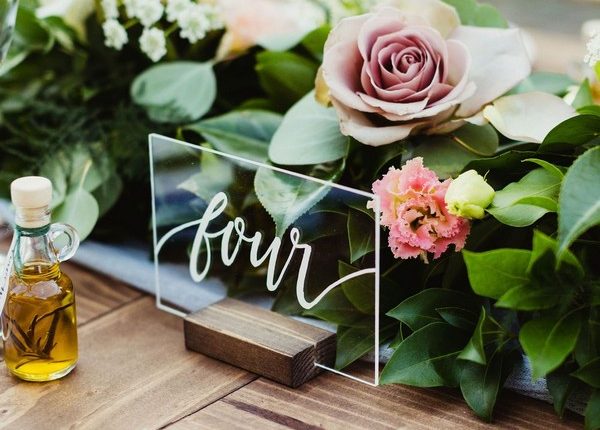simple greenery wedding centerpiece with acrylic table number