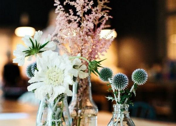 simple mixed bottles and wildflowers wedding centerpiece